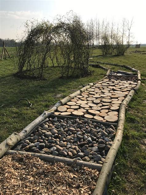 Foto van een blotevoetenpad in een natuurlijke omgeving, met kinderen die erdoorheen lopen