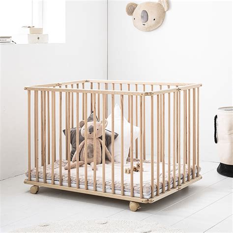 Gedetailleerde afbeelding van een babybox ingericht met een boxkleed, speelgoed en een opbergzak