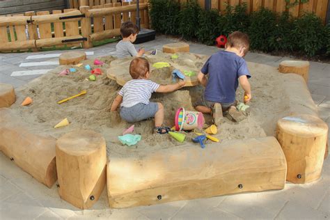 Kinderen die met plezier in een zandbak spelen en constructies bouwen