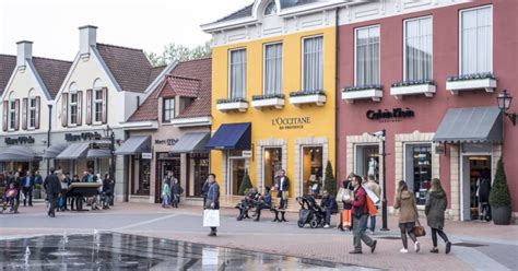 Panorama van het Designer Outlet Roermond met veel winkels en bezoekers