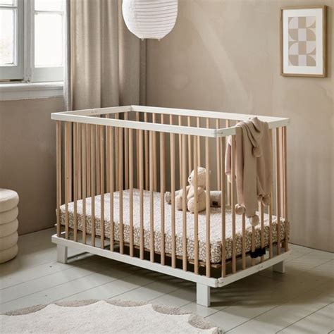 Illustratie van een baby ledikant met een opgemaakt hoeslaken in een neutrale kleur