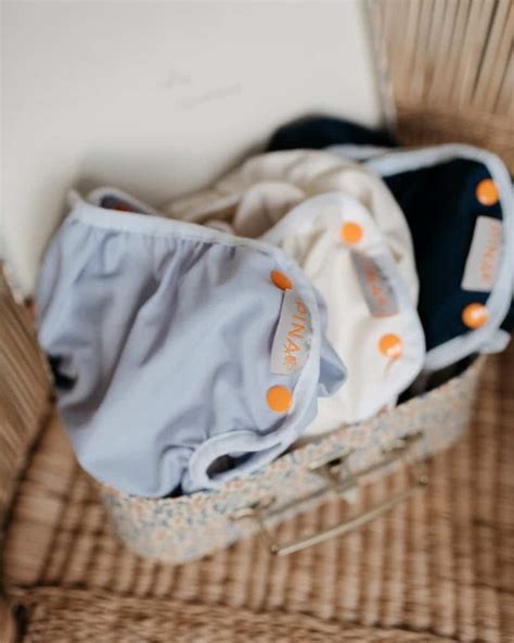 een berg wasgoed met daarin babykleding en wasbare luiers