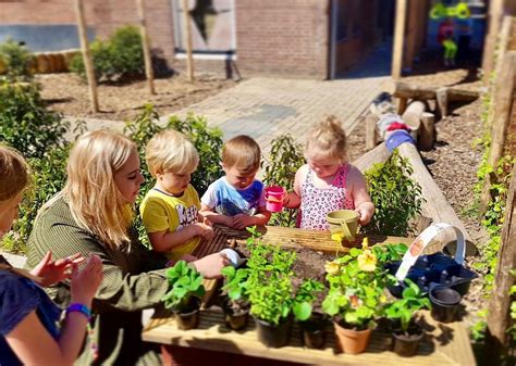 Kinderen spelen in een moestuin met planten en gereedschap.