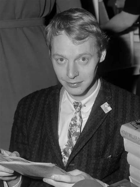 Portret van Simon Vinkenoog in zijn werkruimte, omringd door boeken en manuscripten.