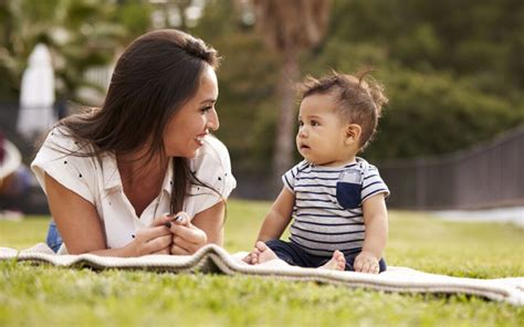 Ouder die lachend oogcontact maakt met baby in een op de ouder gerichte kinderwagen.