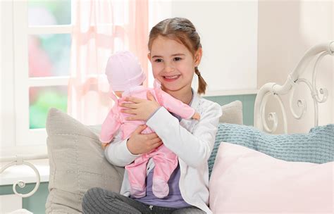 Een kind knuffelt met een pop naast een babybedje.