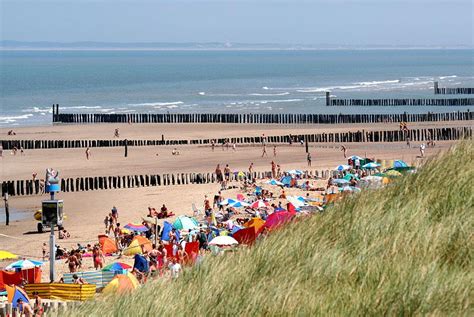 Brede stranden van Zeeland met gezinnen die genieten van de buitenlucht