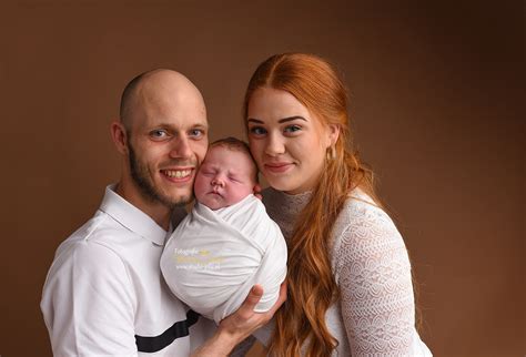 Gezinsfoto met pasgeboren baby in een huiselijke sfeer