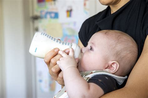 illustratie van een baby die onrustig drinkt aan de borst, met pijlen die de melkstroom en verslikking aanduiden