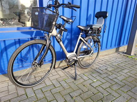 Illustratie van een fiets met een dubbele standaard die stabiliteit biedt bij het plaatsen van een kinderzitje.