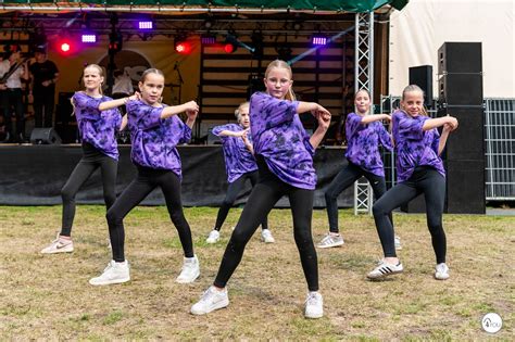 Groep jonge kinderen die dansen met een lachende docent