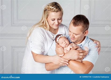 Foto van een gelukkige familie met pasgeboren baby en kraamverzorgende.