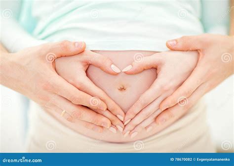 Partner en oudere dochter leggen hun handen op de zwangere buik