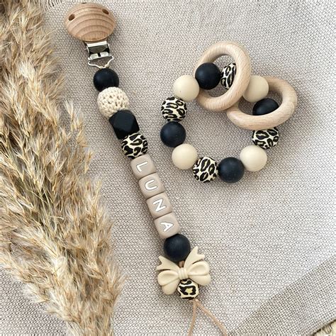 Illustratie van een baby met een speenkoord aan zijn kleding bevestigd.