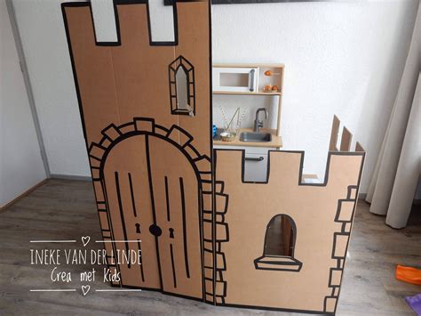 Een gedetailleerd kartonnen kasteel met torens, ramen en een poort, klaar om te beschilderen.