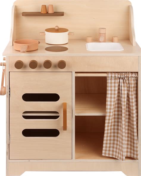 Een kind speelt met een houten keukentje, waarbij hij doet alsof hij kookt.