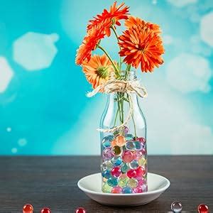 Decoratieve vaas gevuld met kleurrijke waterparels en bloemen.