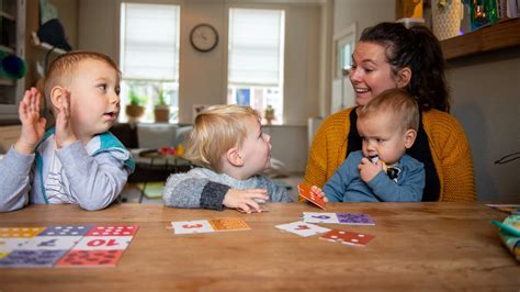 Foto van een gastouder die met kinderen speelt in een huiselijke omgeving