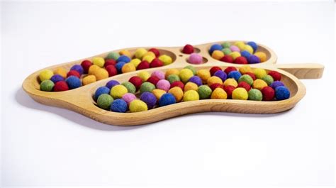 Houten sorteerbak in de vorm van een blad, gevuld met diverse kleine objecten.