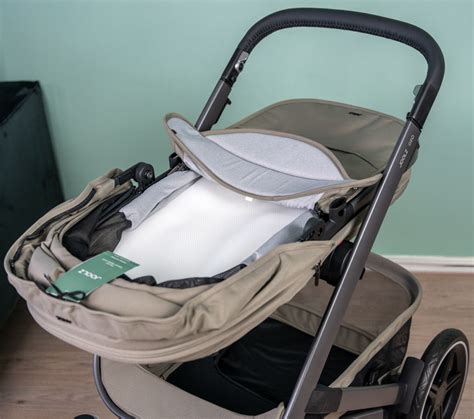 Illustratie van hoe een autostoeltje op het onderstel van de Joolz Geo kinderwagen wordt geklikt met adapters.