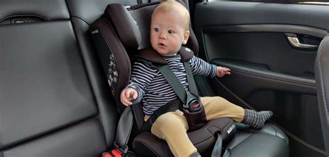 Illustratie van een baby in een autostoel met een vrolijk gekleurde hoes