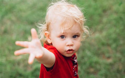 Een peuter die vol bewondering naar een grote brandweerauto kijkt.