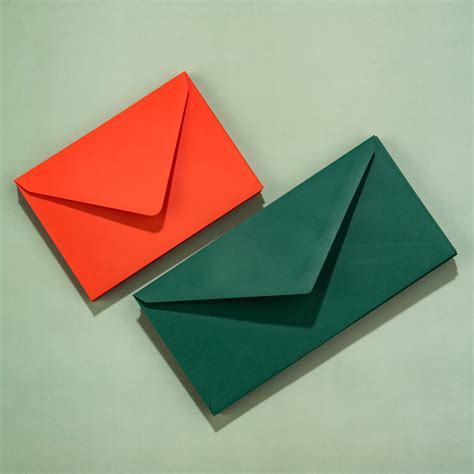 Overzicht van verschillende gekleurde enveloppen, speciale postzegels en sluitzegels voor geboortekaartjes.