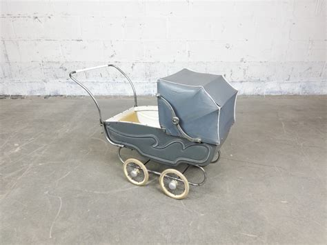 Een sfeervolle foto van klassiek houten speelgoed zoals een poppenwagen en een speelkeukentje.