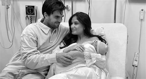 Familiefoto van Kae Sutherland, Diego en hun dochter Loua, met nadruk op Kae's zwangerschapsbuik.