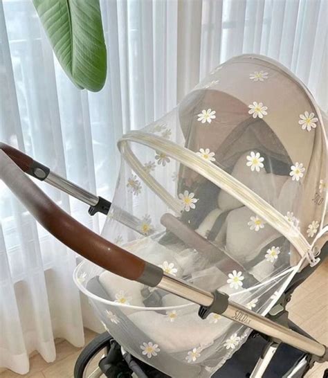 illustratie van een kinderwagen met open kap en parasol ter bescherming tegen de zon