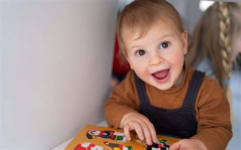 Een peuter van 18 maanden die een vormpuzzel met verschillende geometrische figuren oplost