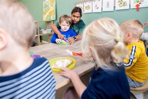 Pedagogisch medewerker die samen met kinderen eet
