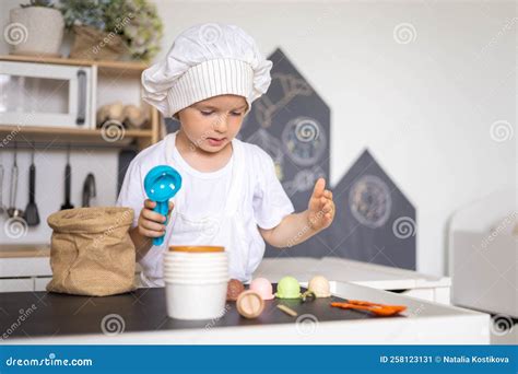 Een kind dat speelt met een houten keuken.