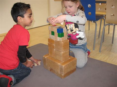 Kinderen die samen een groot bouwwerk maken met Kapla-blokken