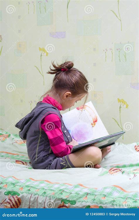 Een kind leest een boek in een gezellige, huiselijke zithoek.