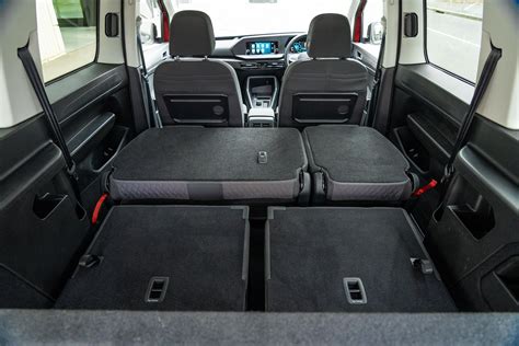 Foto van de achterkant van een Volkswagen Caddy stoel, waarop de verborgen Top Tether bevestigingshaak wordt getoond.