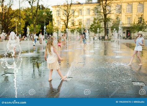 kinderen die spelen rond fonteinen op een zonnig plein