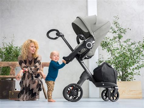Stokke Xplory V6 kinderwagen in gebruik, met ouder en kind die oogcontact maken dankzij de hoge plaatsing van de zitting.