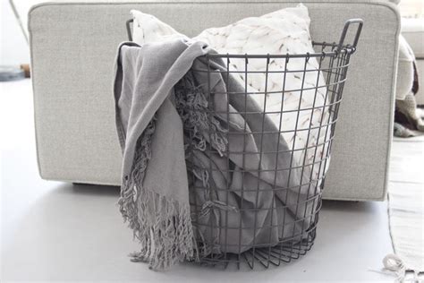 Fotograaf legt baby in een mand gevuld met zachte dekens.