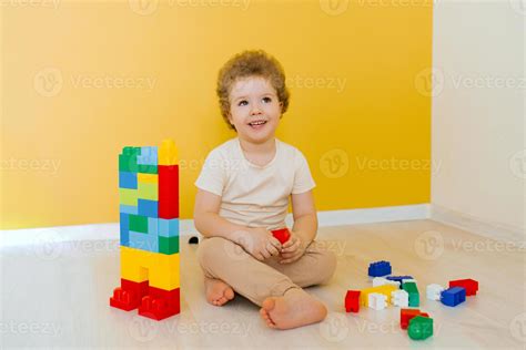 Foto van een kind dat geconcentreerd bouwt met kleurrijke blokken