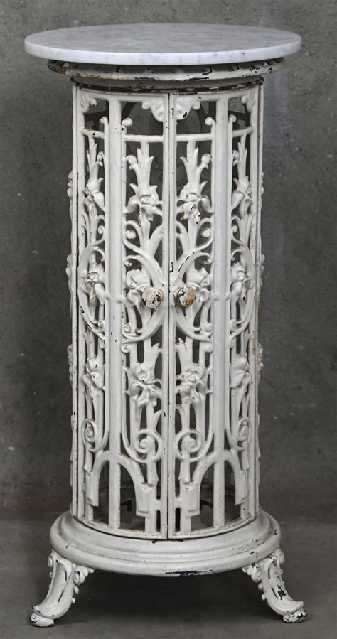 Een gerestaureerd gietijzeren ledikant dat is omgebouwd tot een stijlvolle tuinbank, versierd met bloempotten en kussens.