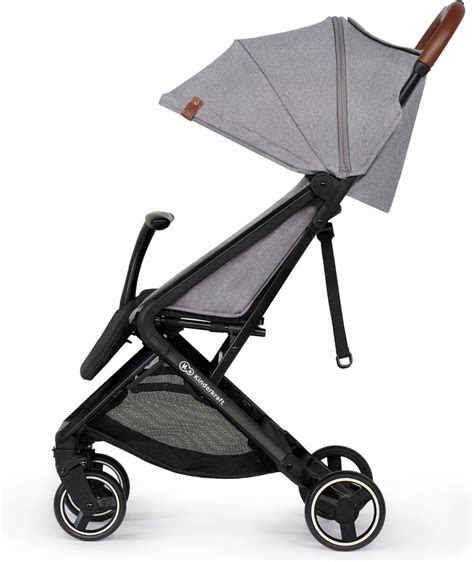 Foto van de Kinderkraft buggy die compact is ingeklapt, naast een auto.