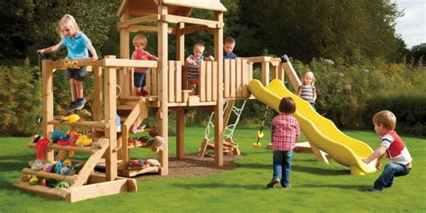 kinderen die buiten spelen in een tuin met speeltoestellen en een buitenkeuken