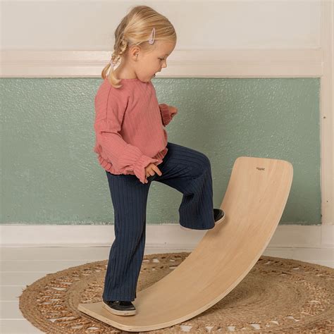 Afbeelding van een kind dat balanceert op een houten balance board