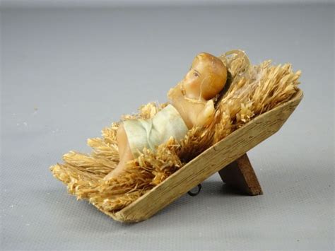 stilleven met een kribbe, stro en een engelachtig figuur