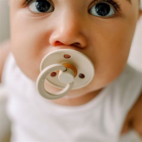 baby oefent met speen naar mond brengen