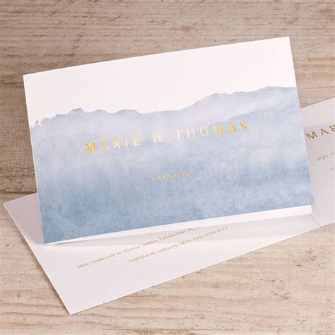 Illustratie van verschillende blauwe geboortekaartjes met aquarel effecten en goudfolie accenten.