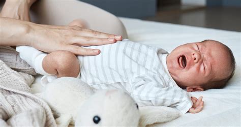 Illustratie van een ouder die een baby met krampjes troost