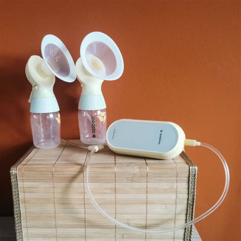 Foto van een moeder die de Medela Freestyle Flex borstkolf draagt, met de cups verborgen in haar voedingsbh.