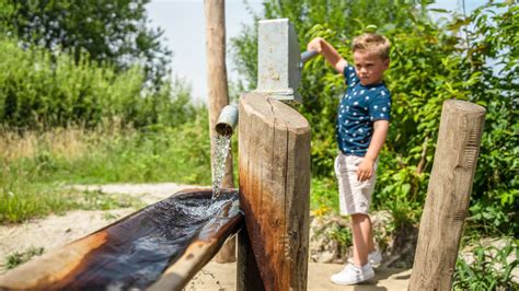 een kind dat speelt met een waterbaan in de tuin